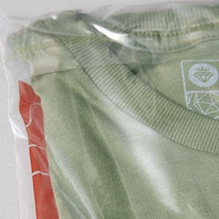 Foto com detalhe da camiseta dobrada na embalagem